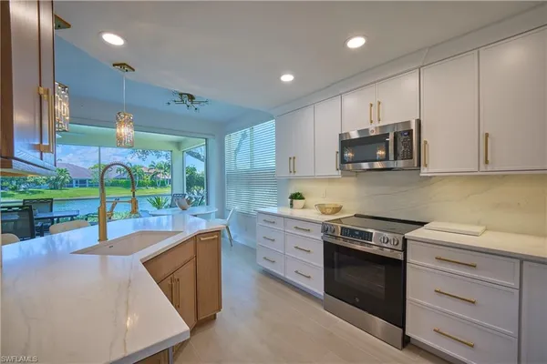 a kitchen with kitchen island granite countertop white cabinets and black stainless steel appliances