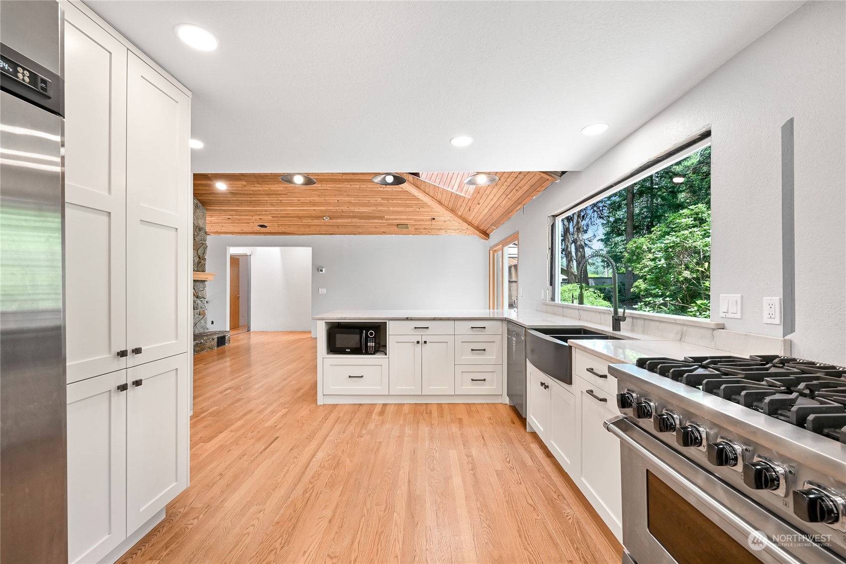 615 Canyon View Road Bellingham, WA 98225 - Photo 17 of 39 a kitchen with stainless steel appliances a stove a sink and white cabinets with wooden floor