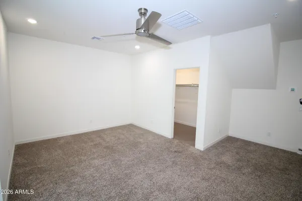 an empty room with a ceiling fan and window