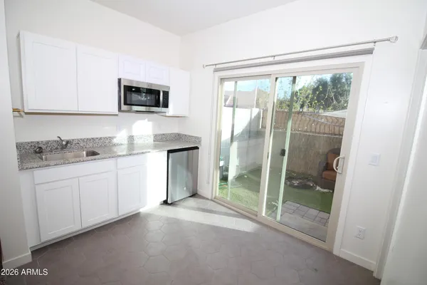 a spacious bathroom with a granite countertop sink and a mirror