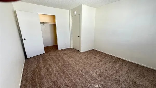 an empty room with wooden floor and mirror