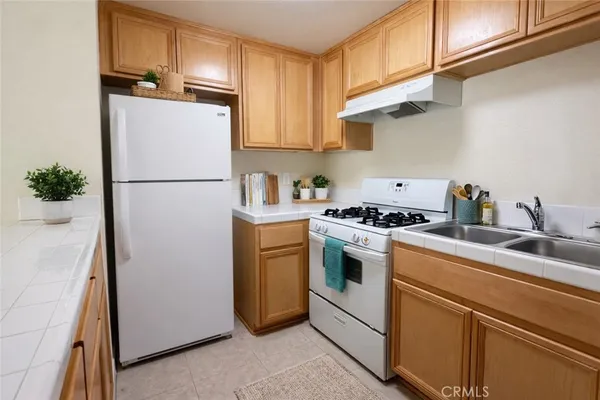 a kitchen with a refrigerator sink stove and cabinets