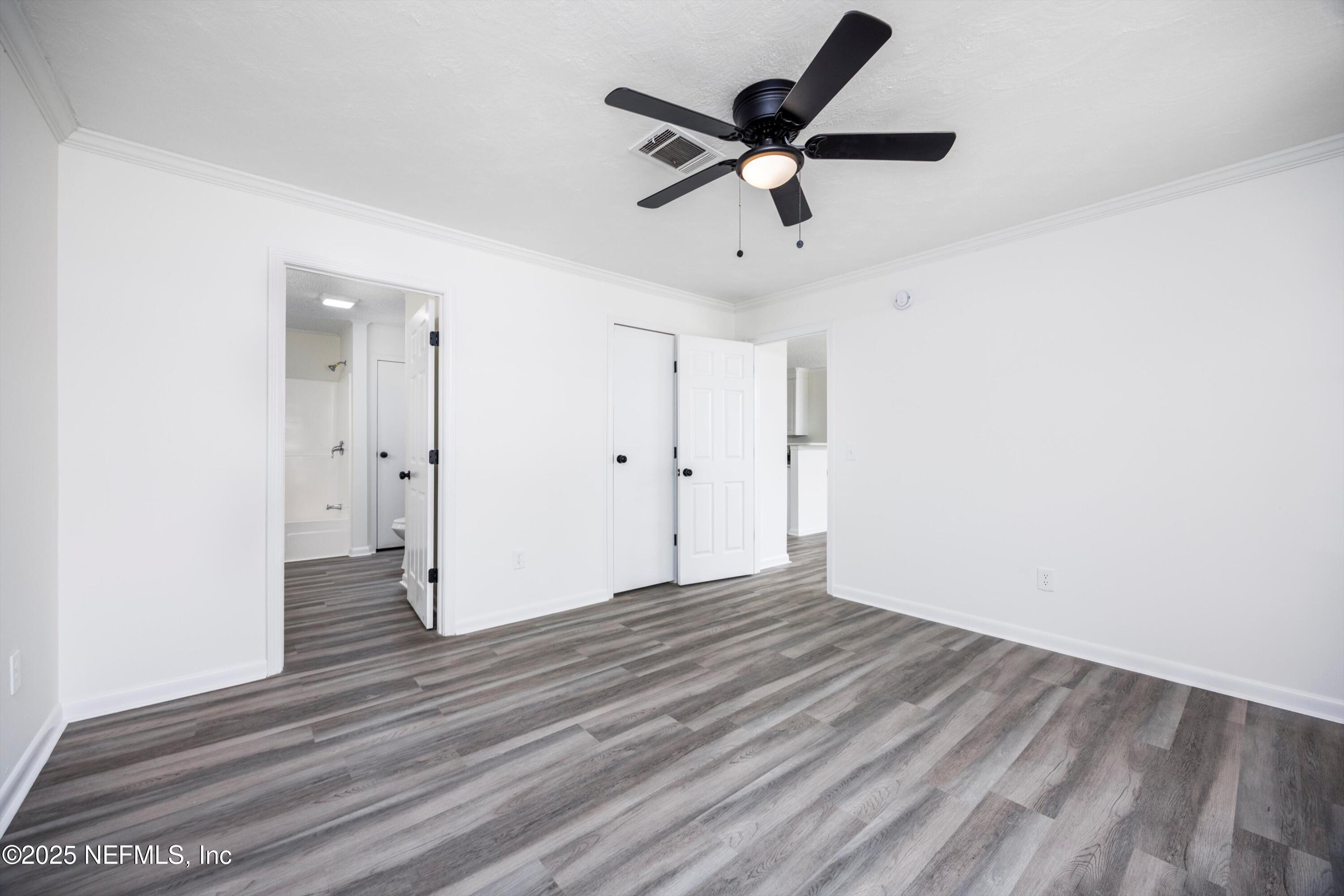900 Helen Street St. Augustine, FL 32084 - Photo 12 of 30 an empty room with wooden floor and a ceiling fan