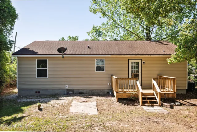 a view of backyard with a chair and wooden fence