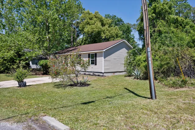 a view of backyard of house with green space