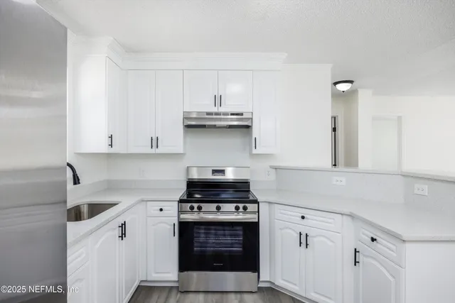 a kitchen with stainless steel appliances granite countertop a stove and a sink