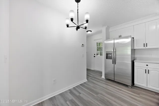 a view of a kitchen with a refrigerator a ceiling fan and wooden floor