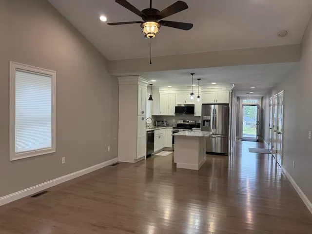 a open kitchen with white cabinets and stainless steel appliances