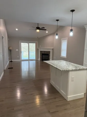 an open kitchen with fireplace and wooden floor