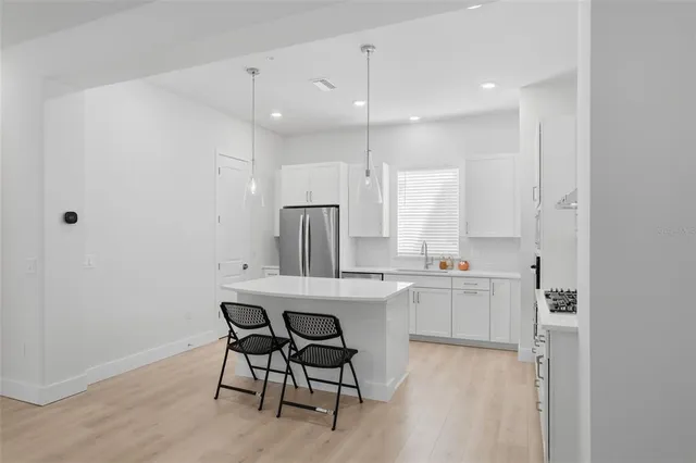 a kitchen with kitchen island a sink stove and white cabinets