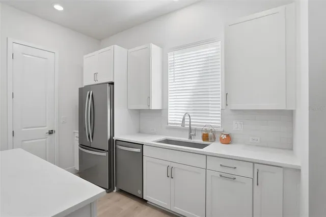 a kitchen with stainless steel appliances a refrigerator sink and cabinets