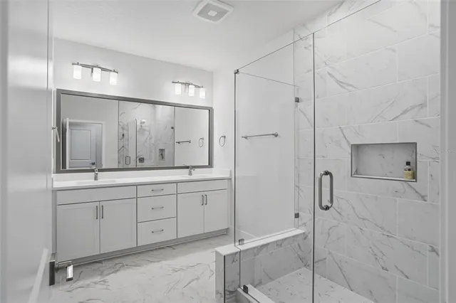 a bathroom with a shower sink and mirror