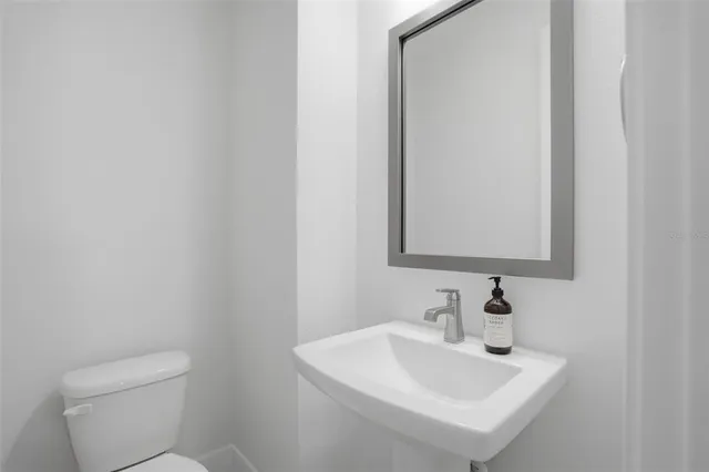 a bathroom with a sink a toilet and mirror