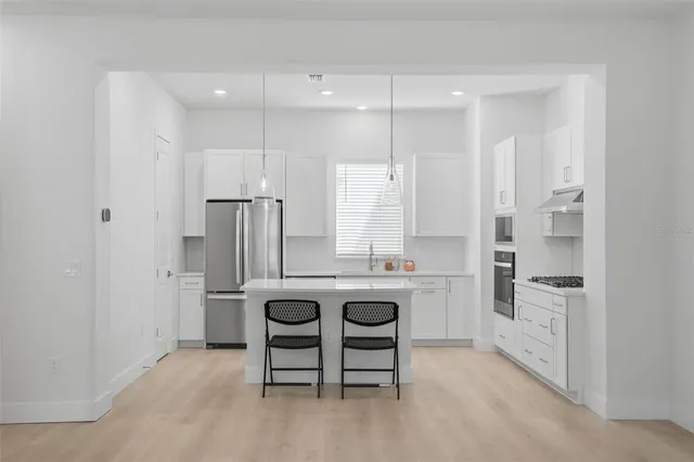 a kitchen with stainless steel appliances a refrigerator and a stove top oven