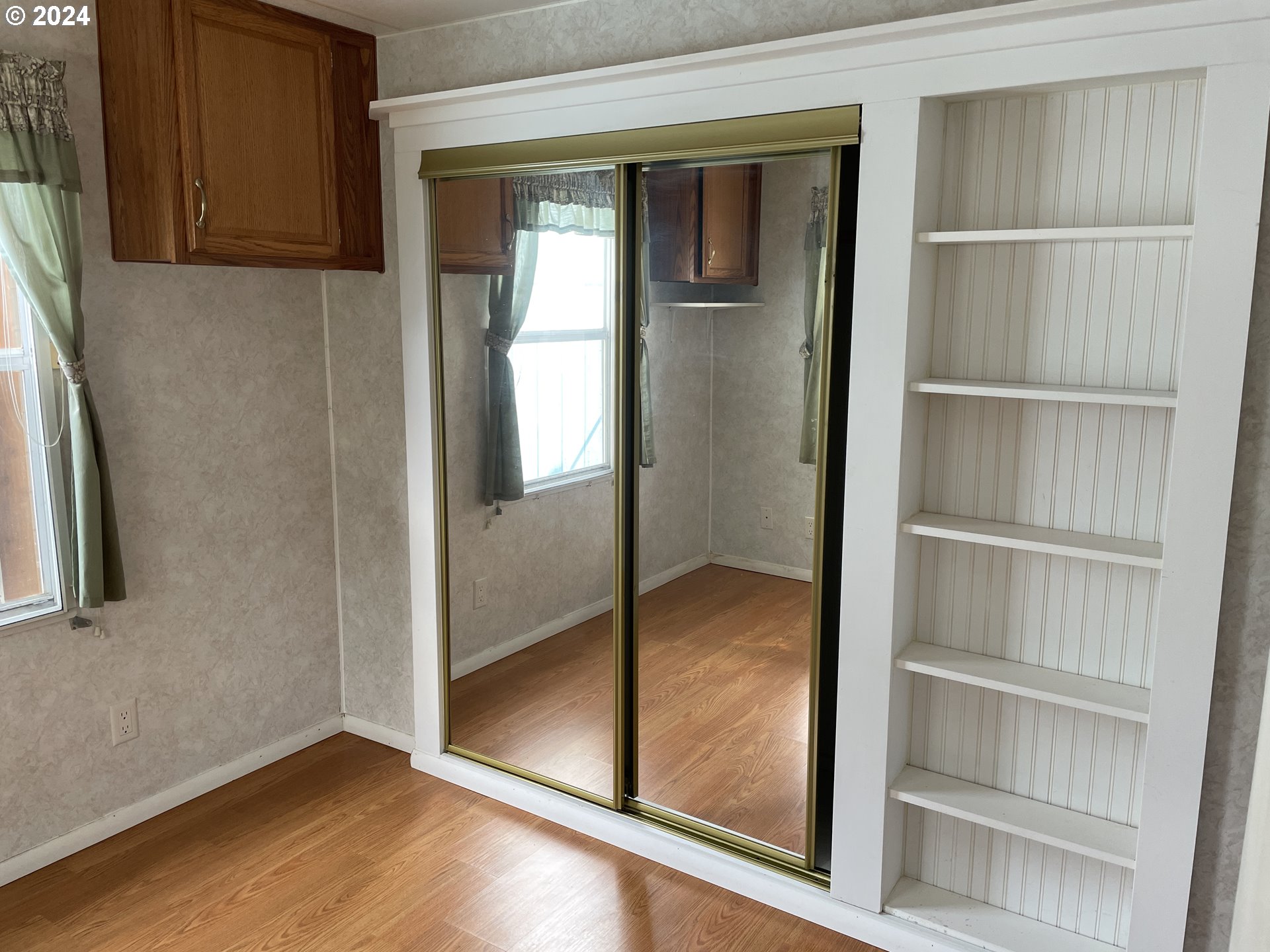 206 Bourbon Street Florence, OR 97439 - Photo 18 of 28 a view of an empty room with wooden floor and a window