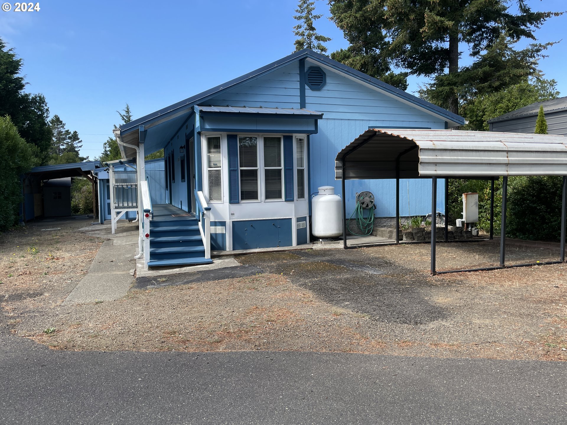 206 Bourbon Street Florence, OR 97439 - Photo 2 of 28 a patio with a table and chairs under an umbrella