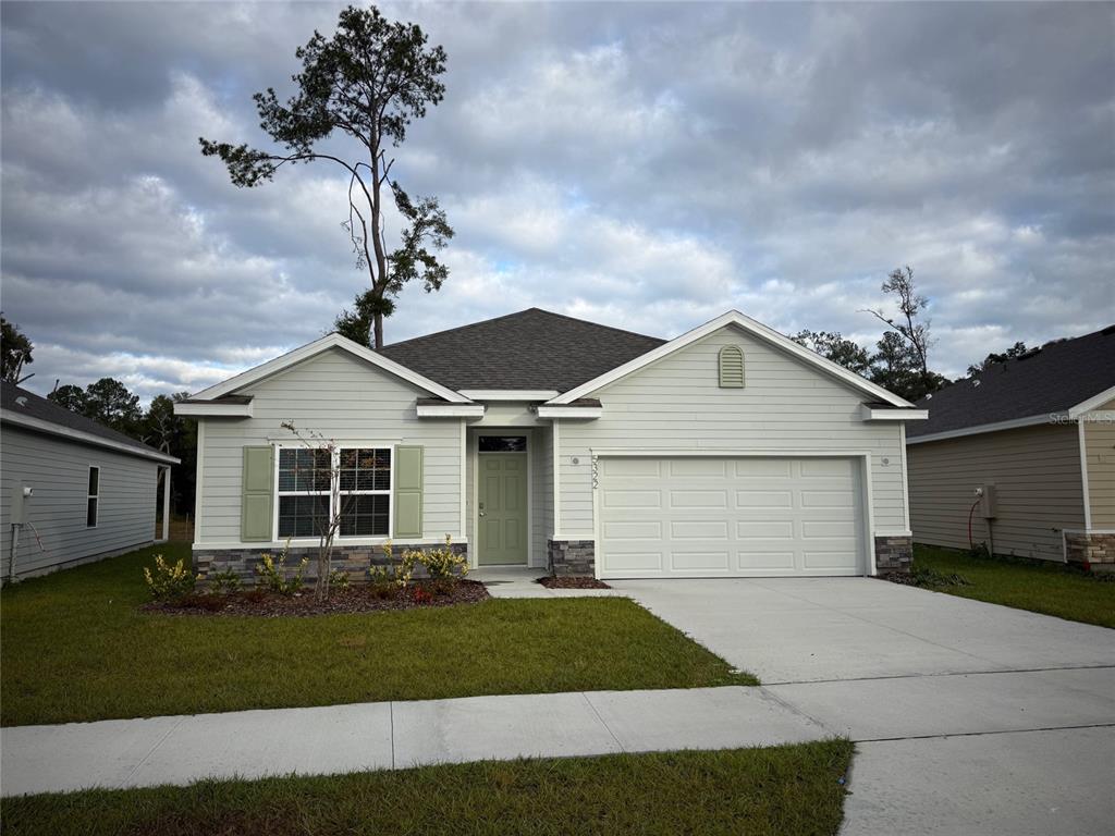 a front view of a house with a garden and yard