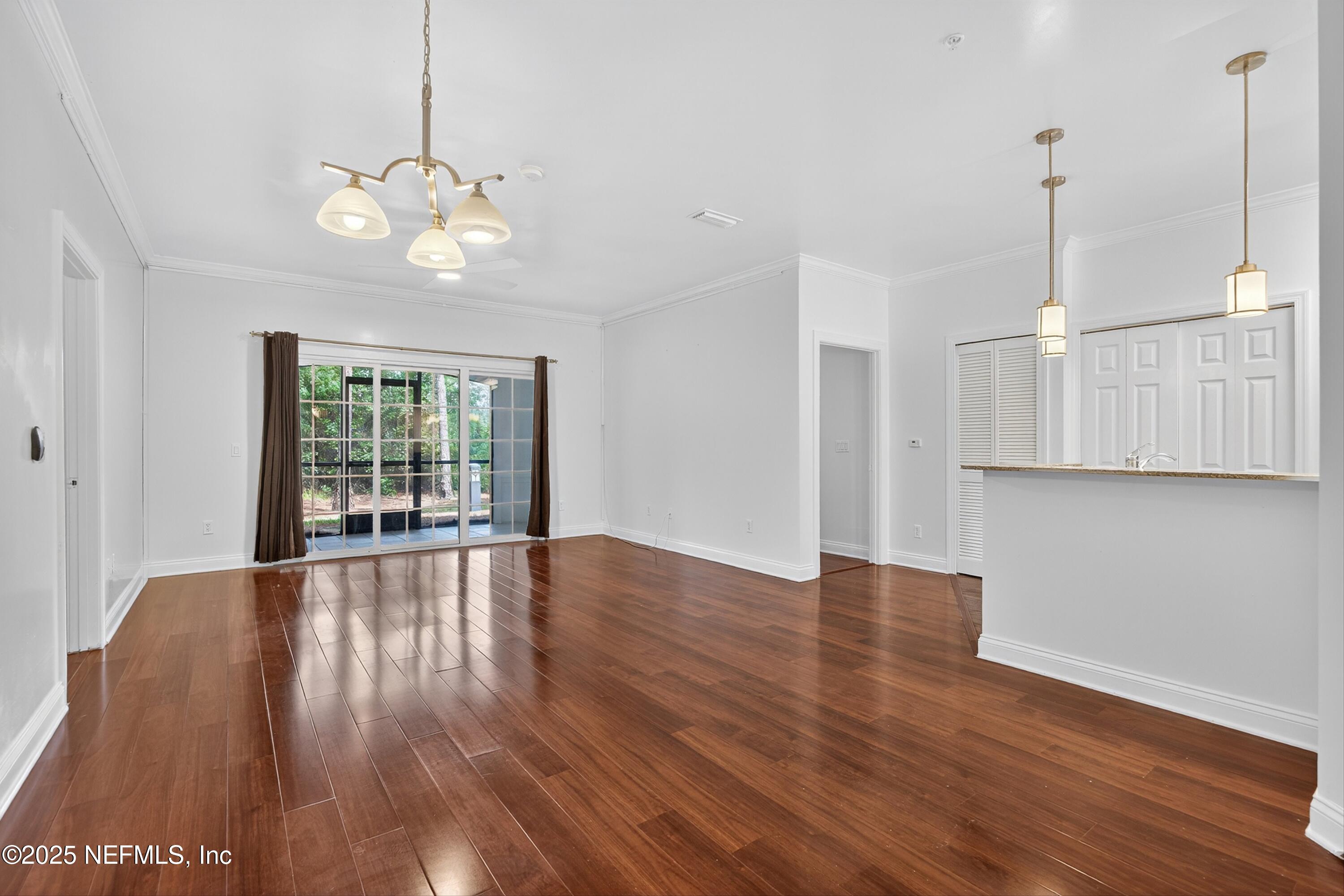 210 Presidents Cup Way, Unit 101 St. Augustine, FL 32092 - Photo 13 of 37 a view of an empty room with wooden floor and a window