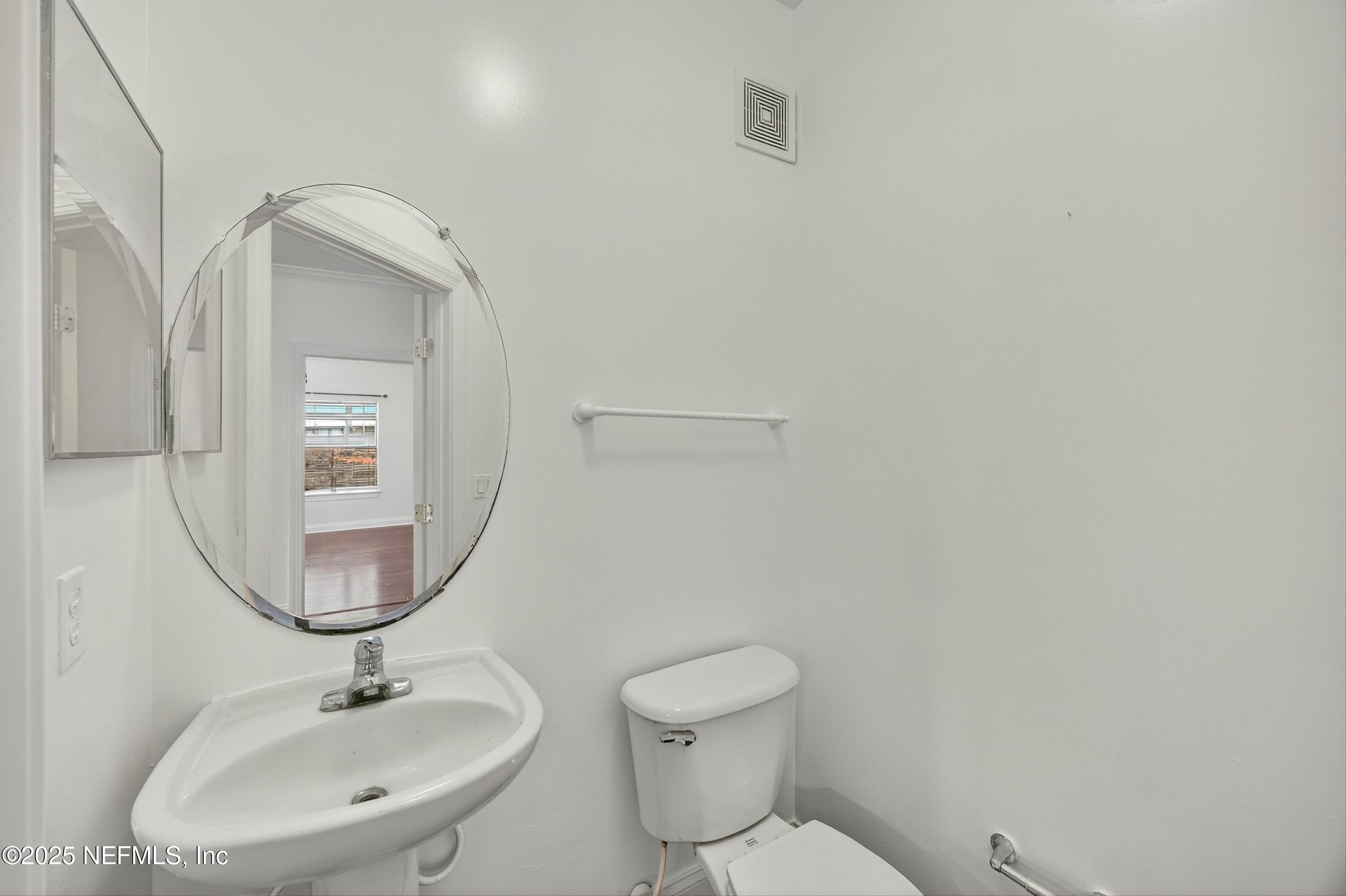 210 Presidents Cup Way, Unit 101 St. Augustine, FL 32092 - Photo 14 of 37 a bathroom with a toilet sink and mirror