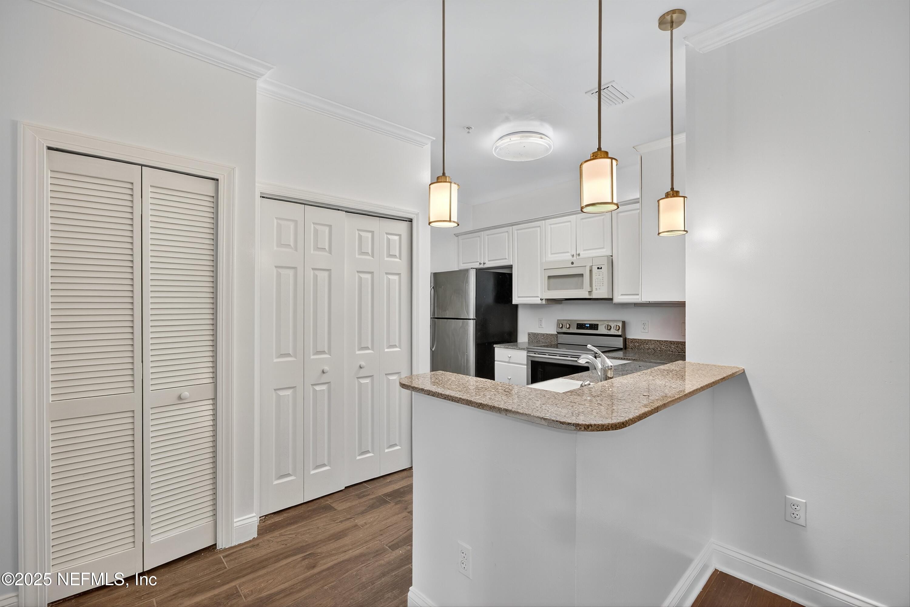 210 Presidents Cup Way, Unit 101 St. Augustine, FL 32092 - Photo 15 of 37 a kitchen with stainless steel appliances granite countertop cabinets a sink and a wooden floor