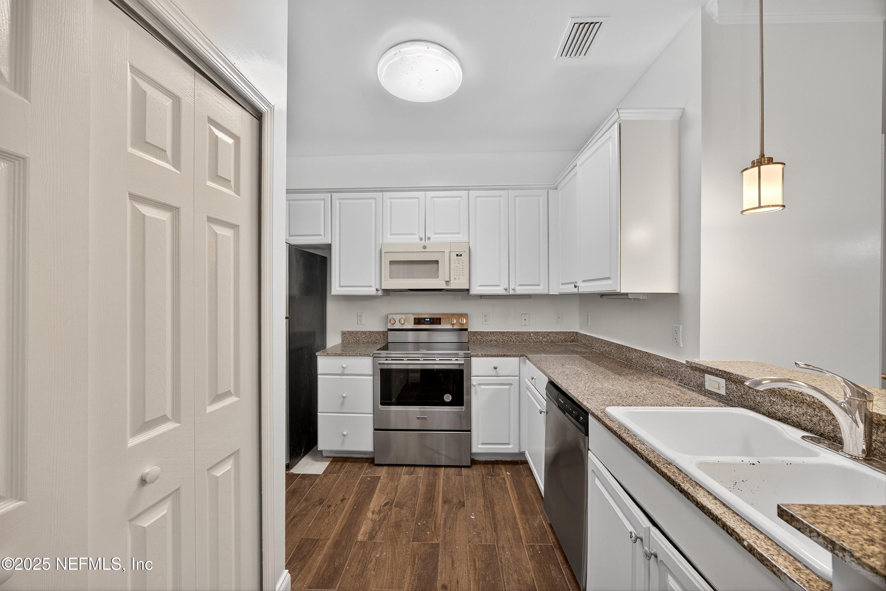 210 Presidents Cup Way, Unit 101 St. Augustine, FL 32092 - Photo 16 of 37 a kitchen with granite countertop a sink stove and refrigerator