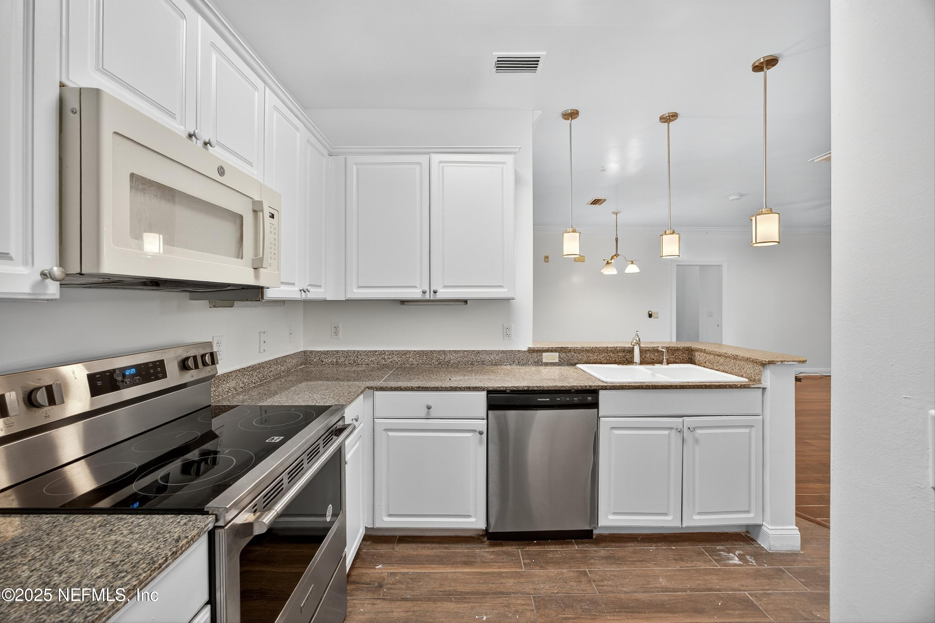 210 Presidents Cup Way, Unit 101 St. Augustine, FL 32092 - Photo 17 of 37 a kitchen with a sink stove and cabinets
