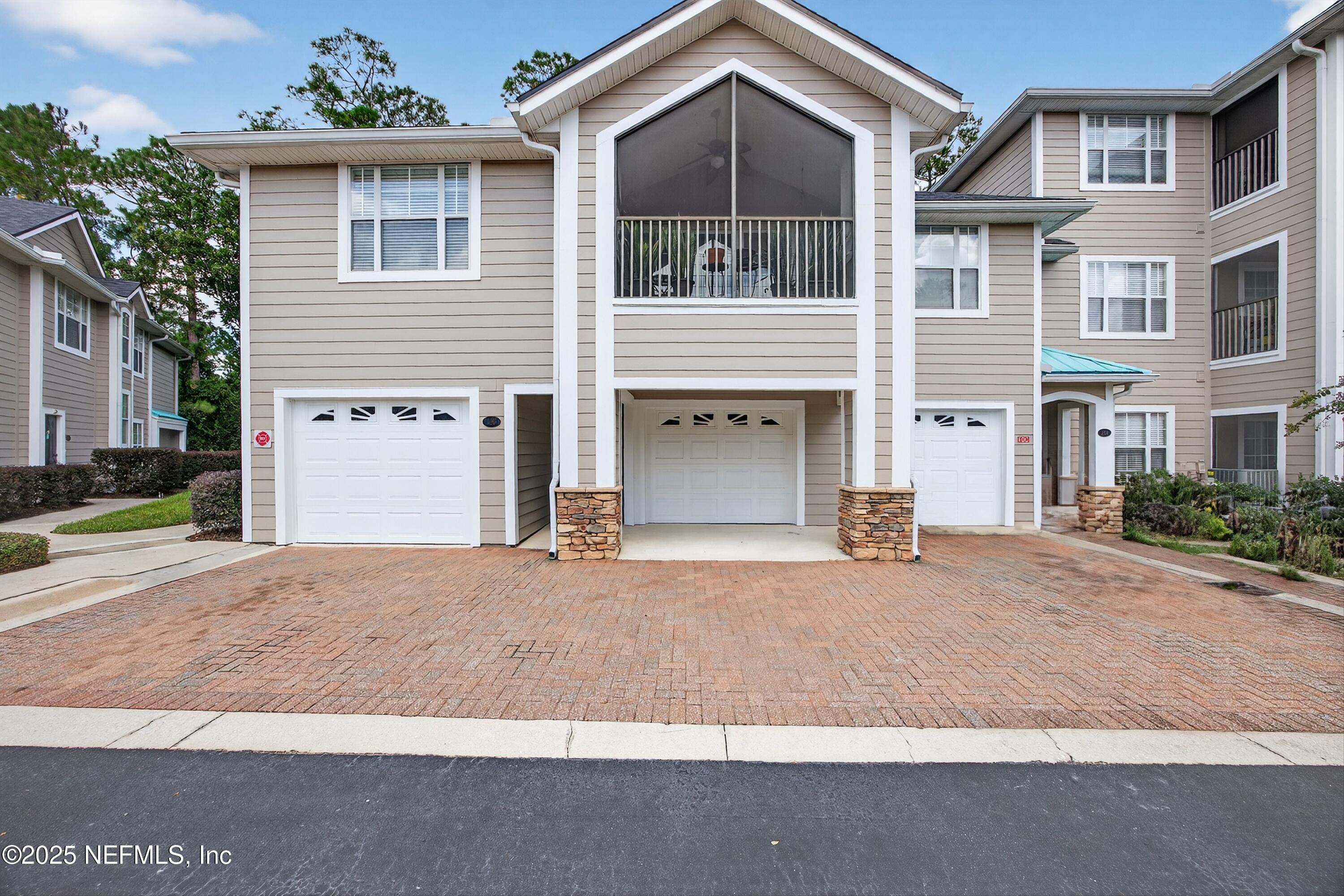210 Presidents Cup Way, Unit 101 St. Augustine, FL 32092 - Photo 2 of 37 a front view of a house with a yard and garage