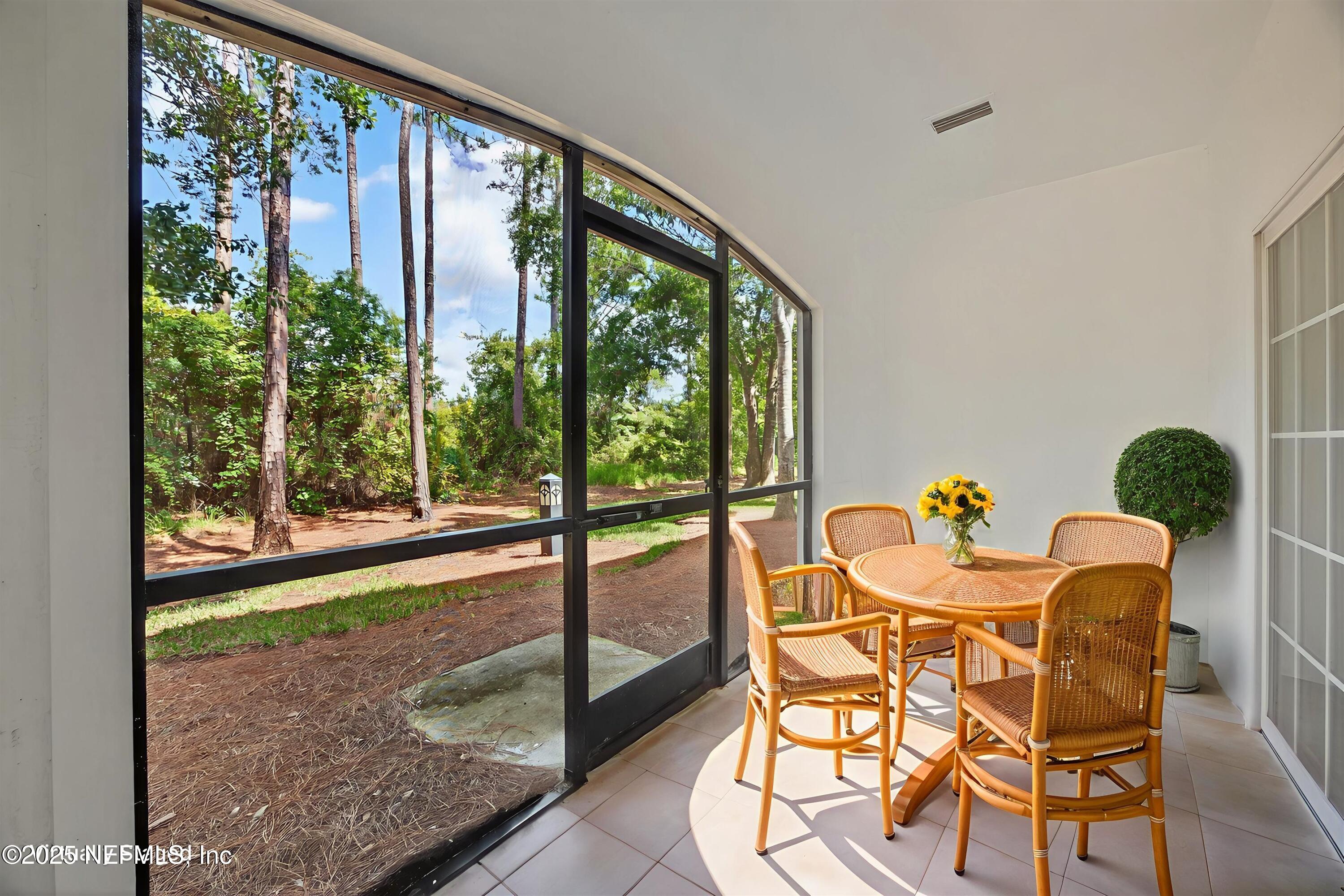 210 Presidents Cup Way, Unit 101 St. Augustine, FL 32092 - Photo 33 of 37 a dining room with wooden floor and a floor to ceiling window