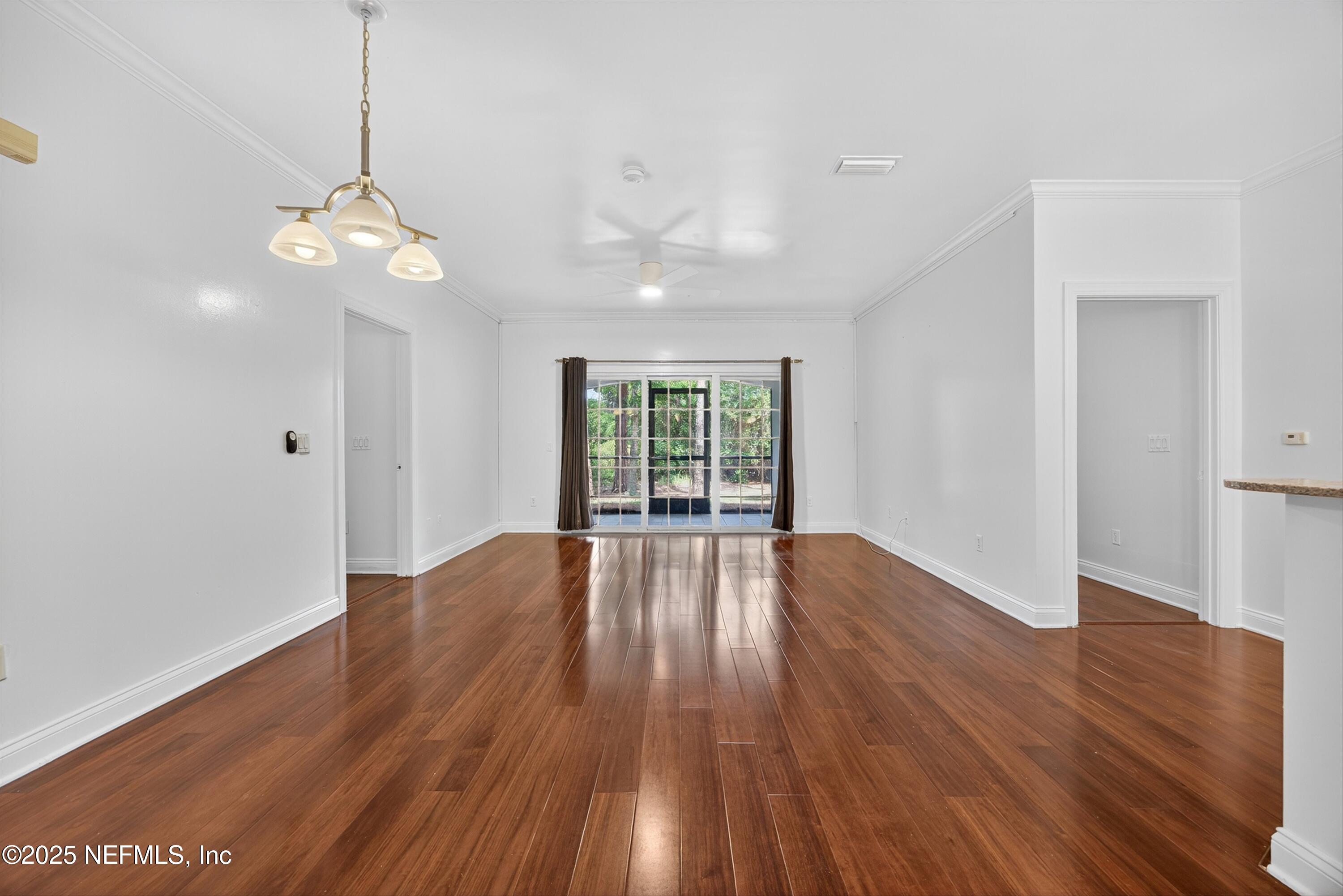 210 Presidents Cup Way, Unit 101 St. Augustine, FL 32092 - Photo 7 of 37 a view of empty room with wooden floor and fan