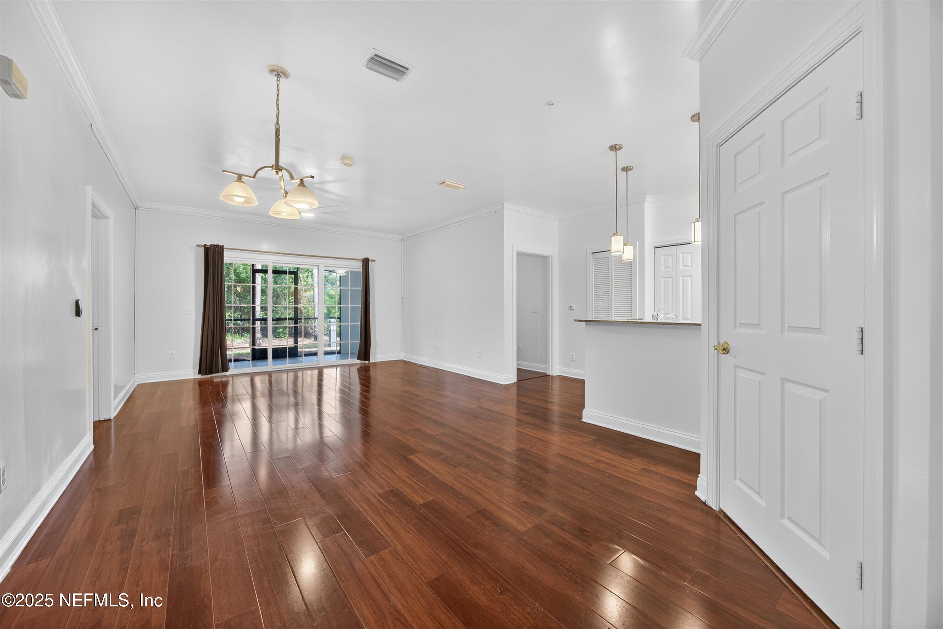 210 Presidents Cup Way, Unit 101 St. Augustine, FL 32092 - Photo 8 of 37 a view of an empty room with wooden floor and a window