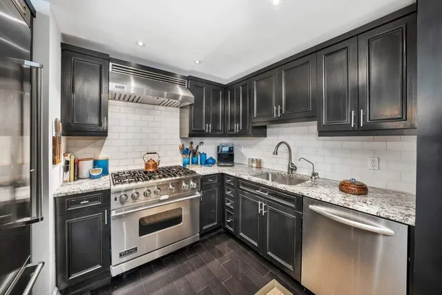 a kitchen with stainless steel appliances granite countertop a sink and a stove