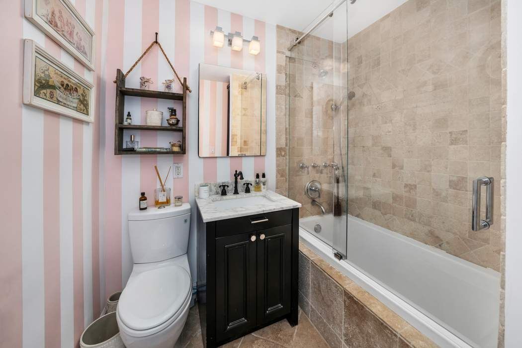 207 East 74th Street, Unit 7F Manhattan, NY 10021 - Photo 7 of 8 a bathroom with a sink a toilet and shower