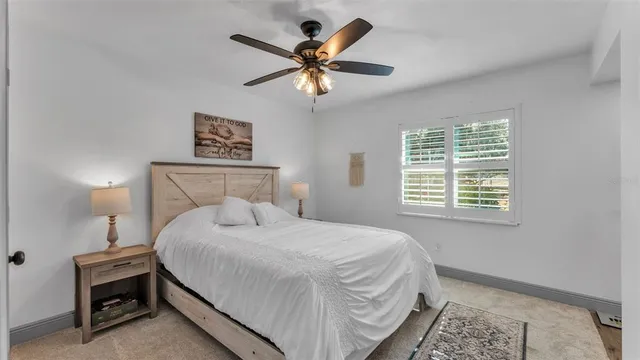 a bedroom with a bed and a ceiling fan