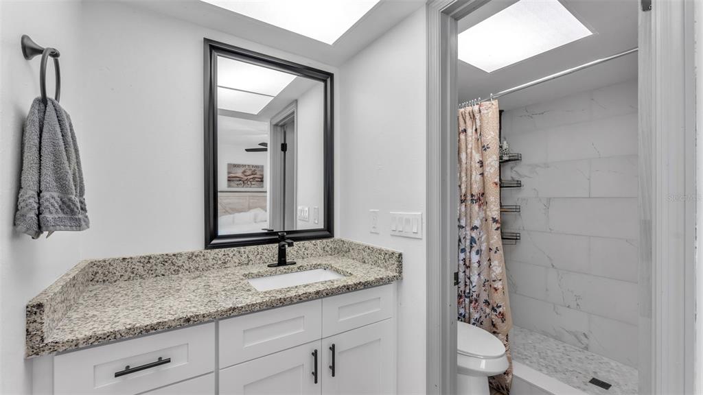 1005 Swilley Road Plant City, FL 33567 - Photo 16 of 24 a bathroom with a granite countertop sink toilet and shower