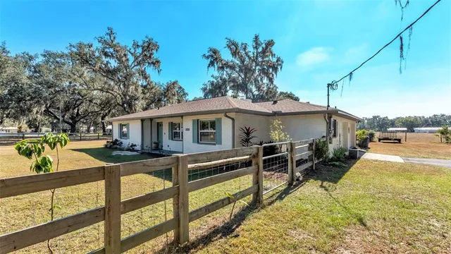 a view of a house with wooden floor next to a yard