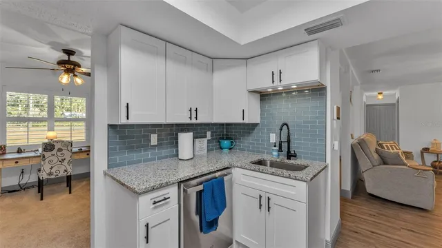 a kitchen with stainless steel appliances granite countertop a sink refrigerator and cabinets