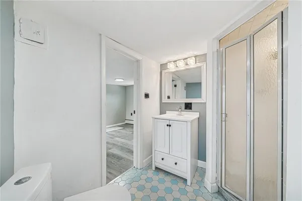 a bathroom with a shower sink and mirror