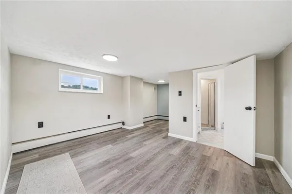 a view of empty room with wooden floor