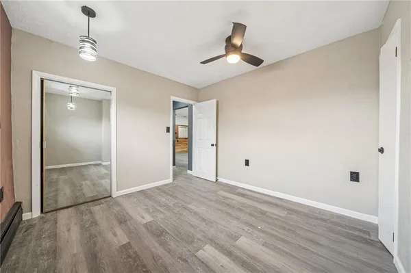 a view of empty room with wooden floor