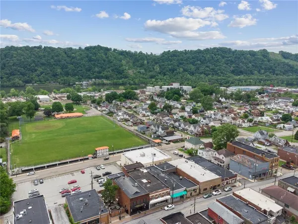 an aerial view of a city with lots of residential buildings and mountain view in back