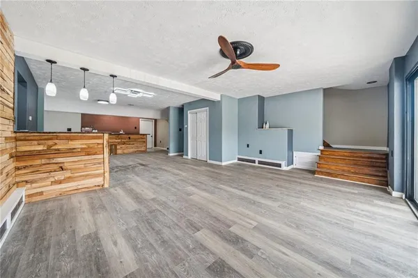 a view of a room with wooden floor and ceiling fan