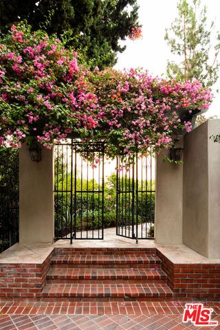 a view of a house with a tree and flower garden