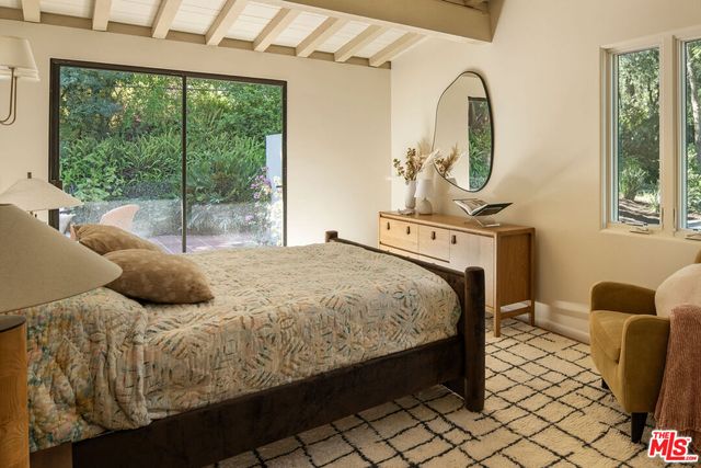 a bedroom with two beds and a large window