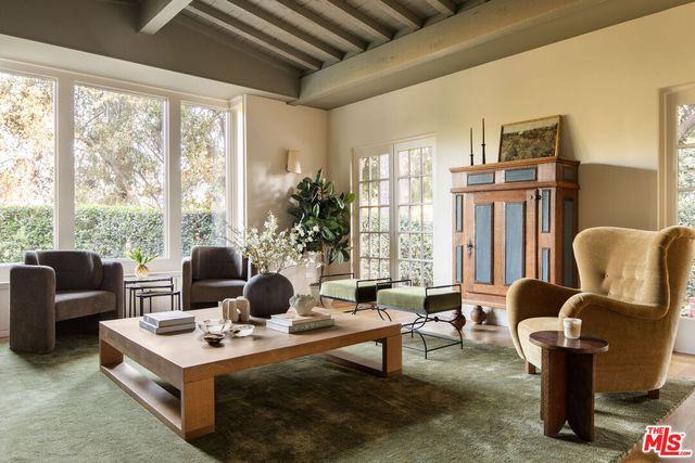 a living room with fireplace furniture and a large window