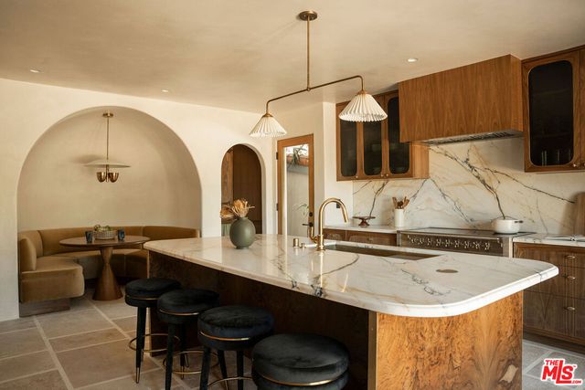 a kitchen with a sink a stove and chairs