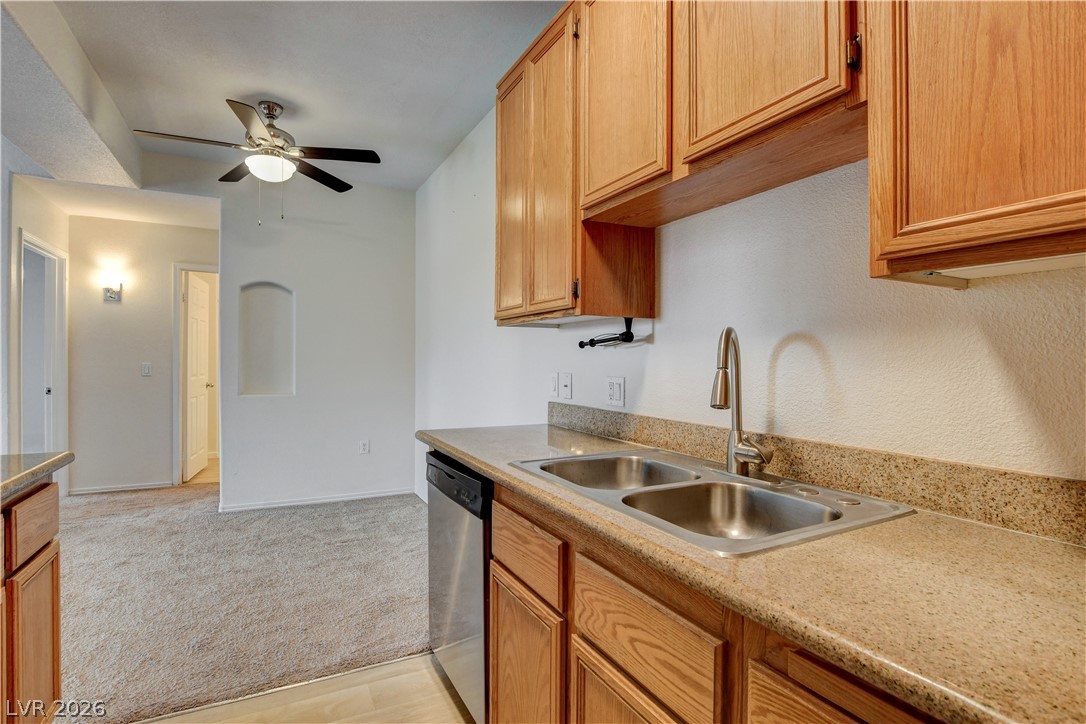 3318 North Decatur Boulevard, Unit 1069 Las Vegas, NV 89130 - Photo 15 of 39 A well-equipped kitchen space features a double basin sink and a ceiling fan in the adjacent living area.