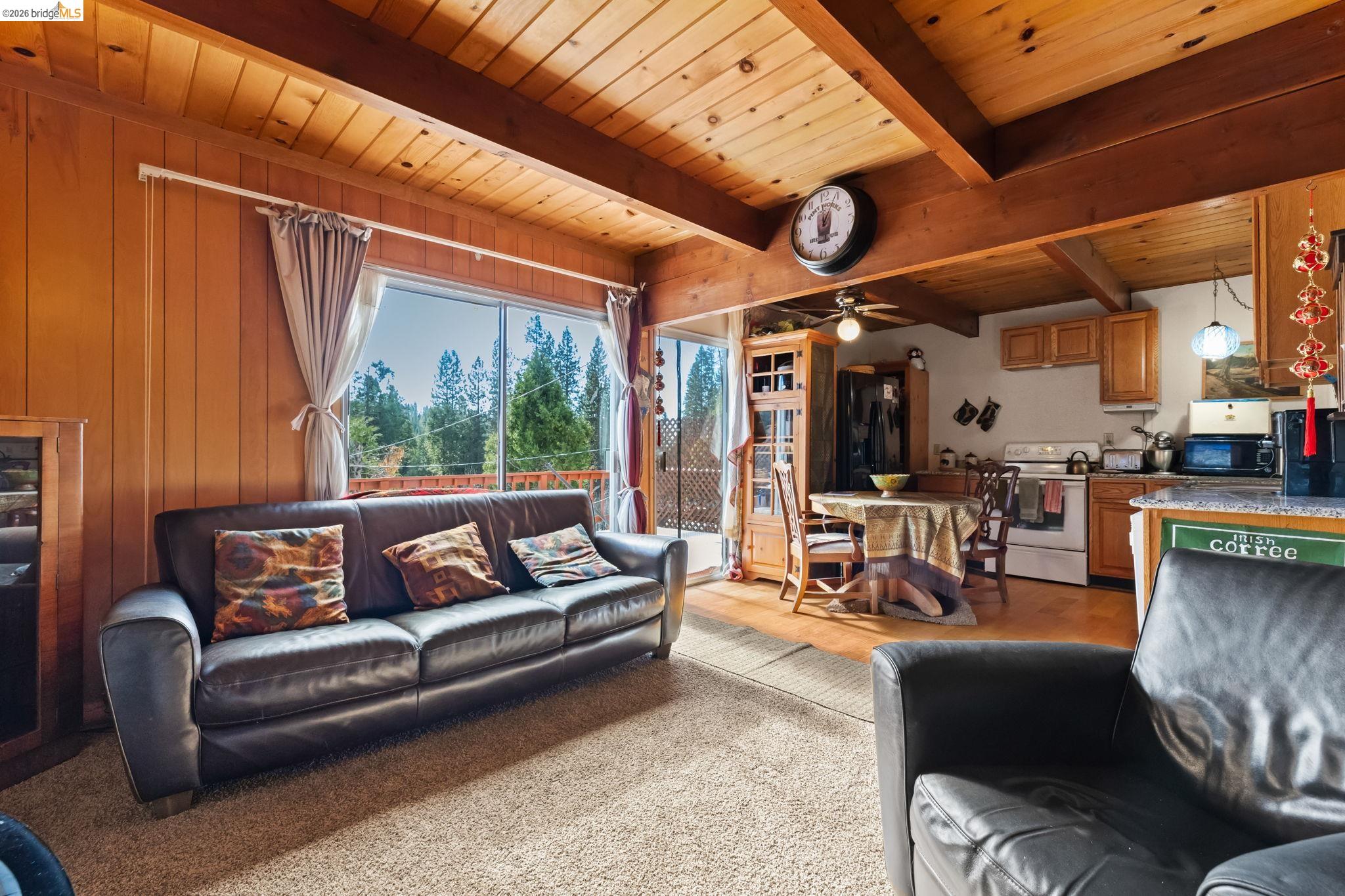 26039 Long Barn Road Long Barn, CA 95335 - Photo 9 of 27 Living room with a wooden ceiling with exposed beams, ceiling fan, and wood walls