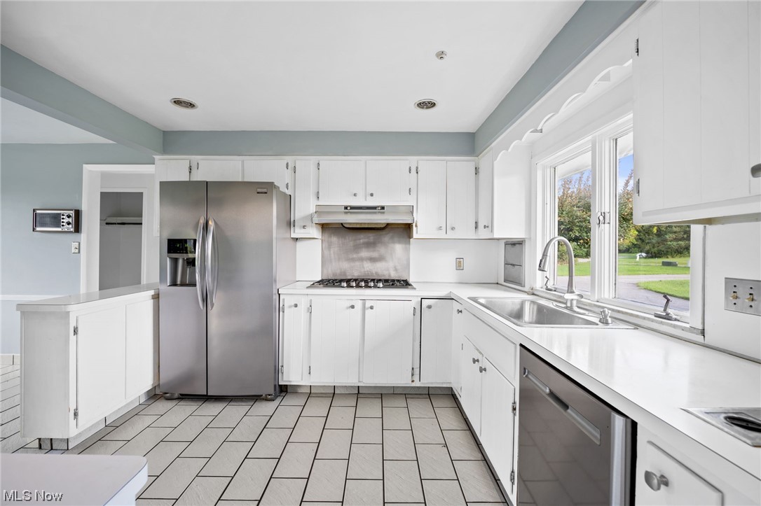 27299 Belgrave Road Cleveland, OH 44124 - Photo 6 of 11 Kitchen with white cabinets, stainless steel appliances, light countertops, and light tile floors
