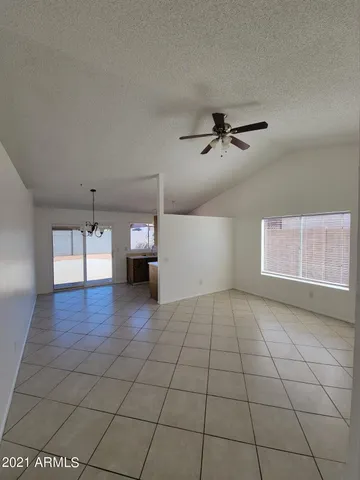 a view of empty room with wooden floor and ceiling fan