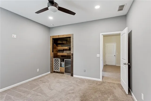 an empty room with closet and a ceiling fan
